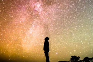 Photo d'une personne qui regarde un ciel jaune et doré